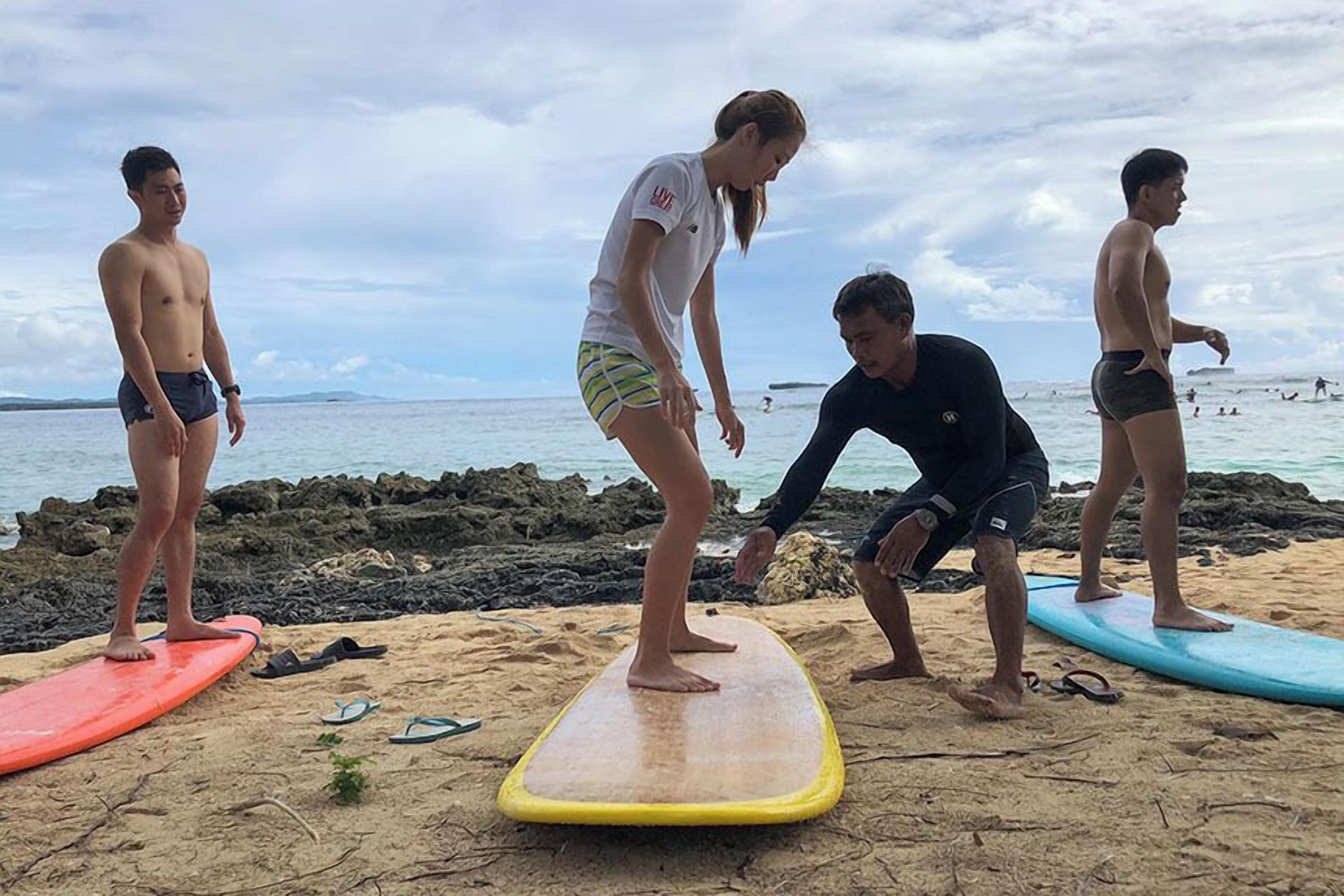 A beach with people standing on surfboards.