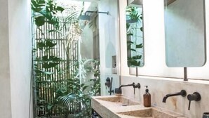 A modern bathroom with two sinks, a wooden ceiling, and a view of a bamboo fence. - Surfing Temple Boutique Hotel (General Luna)