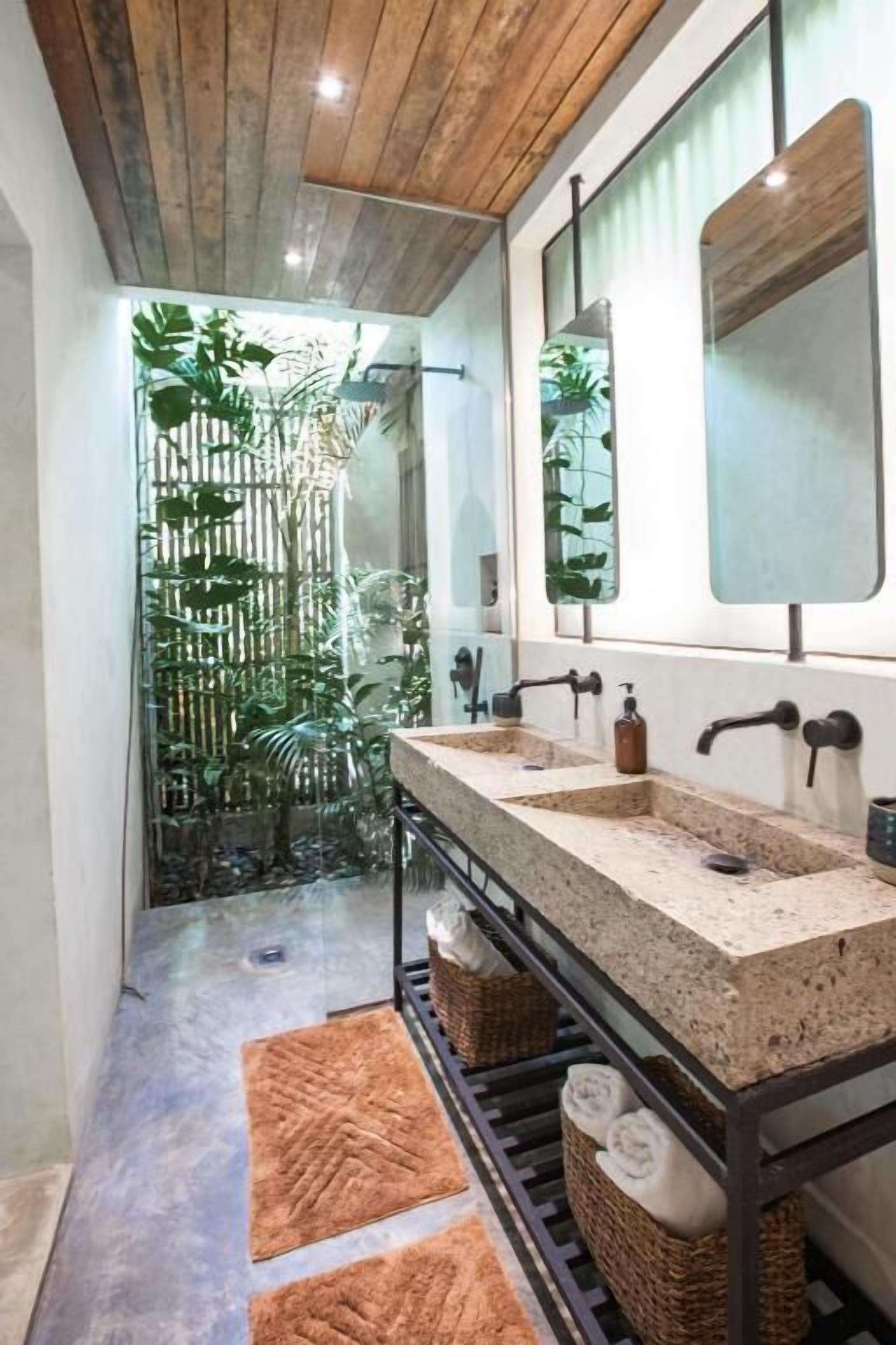 Un baño moderno con techo de madera, dos lavamanos y un espejo grande.