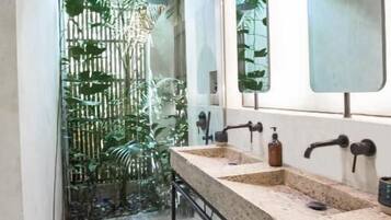 Un baño moderno con techo de madera, dos lavamanos y un espejo grande.