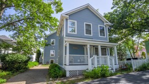 A two-story house with a porch and a small front yard. - Beachwalk Resort Guest House w/Pool, Beach, More (Michigan City)