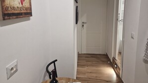 Et spiseområde med et bord dækket til to personer, en vinflaske og en fjernbetjening.