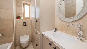 Ein modernes Badezimmer mit Toilette, Waschbecken und Spiegel.