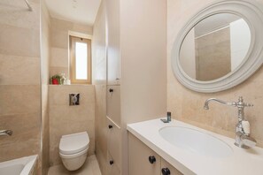 A modern bathroom with a toilet, sink, and mirror. - 4 BR Apartment in Sarei Israel Blvd (w/ safe room) (Jerusalem)