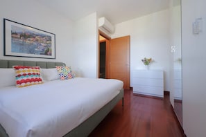 A bedroom with a bed, pillows, a dresser, and a framed picture on the wall. - Modern flat with terrace near Eataly (Roma)