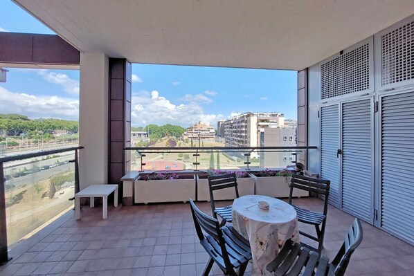 A balcony with a table and chairs, a bench, and a view of the cityscape. - Modern flat with terrace near Eataly (Roma)