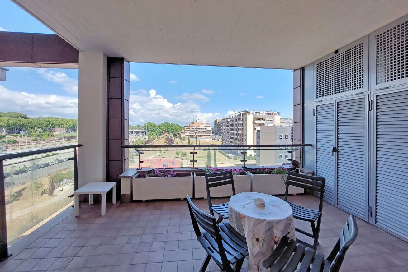 Ein Balkon mit Tisch, Stühlen und einer Bank, mit Blick auf die Stadt.