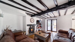 A living room with a fireplace, leather sofas, a coffee table, and a bookshelf.