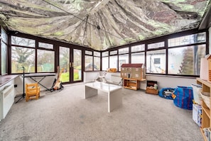 A room with a large window, a white desk, and a bookshelf.
