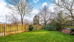 A well-maintained backyard with a wooden fence, a trampoline, and a shed. - Wood burner, two lounges and a large garden for up to 8 guests (South Hiendley)