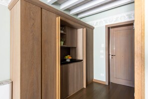 A wooden wardrobe with a black countertop and a potted plant. - 105 Iris Deluxe Room (Palermo)