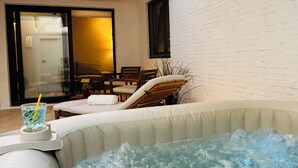 Ein Whirlpool mit Wasser, ein Glas Wasser mit Trinkhalm und zwei Stühle.