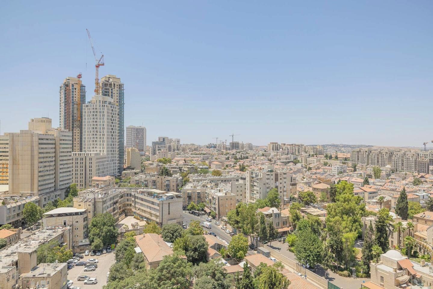 A cityscape with multiple high-rise buildings, a mix of residential and commercial structures, and a clear sky.