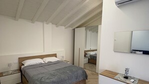 A bedroom with a bed, nightstands, a dresser, a mirror, and an air conditioning unit. - Sweet & home 3 Apartment Delux near Bergamo (Azzano San Paolo)