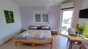 A bedroom with a double bed, a small table, a chair, a window with blinds, and a painting on the wall. - Apartments Lighthouse (Fazana)
