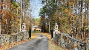 A stone pathway leading to a house surrounded by trees.