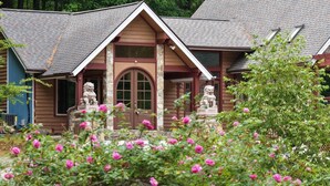 A house with a stone facade, a brown door, and two stone lion statues.