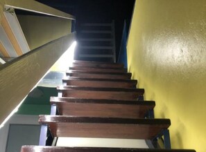 Eine Holztreppe mit Handlauf, die zu einer Zwischenebene führt.
