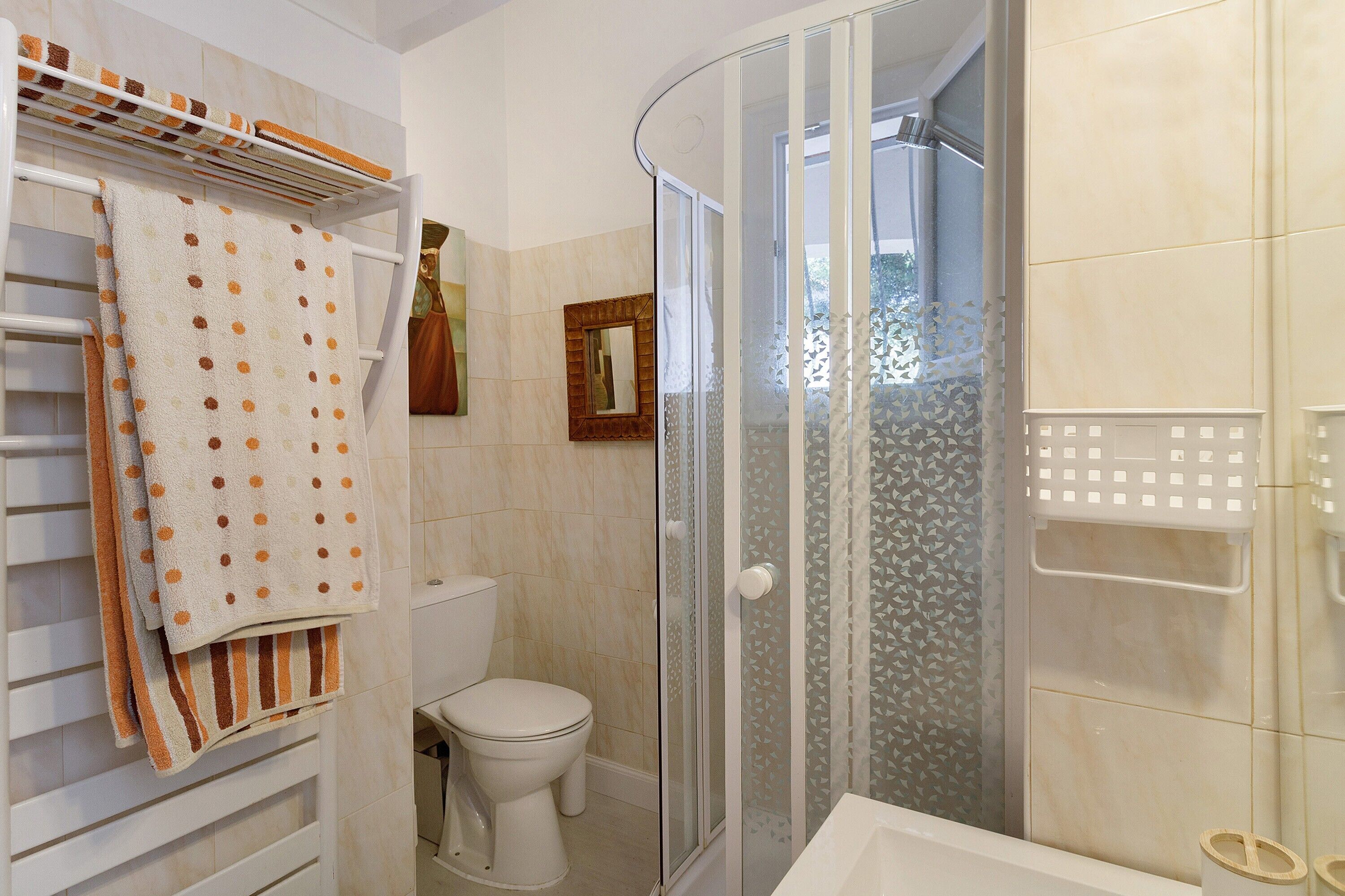 Ein Badezimmer mit Duschkabine, Toilette und Handtuchhalter mit gefalteten Handtüchern.