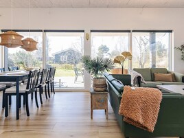 Un amplio espacio de estar con una mesa de comedor, sillas, un sofá y una pequeña mesita auxiliar.