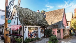 A traditional building with a thatched roof and a shop front with a red and white striped awning. - 3999 Stay at "Cottage by the Sea" in Monterey (Monterey)