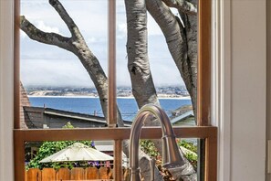 Ein Fenster mit Blick auf Strand und Bäume.