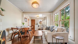 A spacious living room with a sofa, coffee table, and dining area with chairs. - 3999 Stay at "Cottage by the Sea" in Monterey (Monterey)