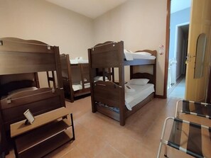 Ein Zimmer mit Etagenbetten, einem kleinen Schreibtisch und einem Stuhl.