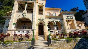 Un bâtiment à deux étages doté d’une entrée centrale, de portes en arc de cercle et d’un balcon avec des balustrades.