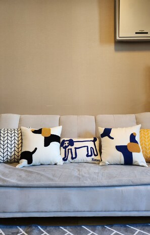 A grey sofa with four decorative pillows featuring abstract animal designs. - KUMA HOUSE MAPO (Mapo gu)