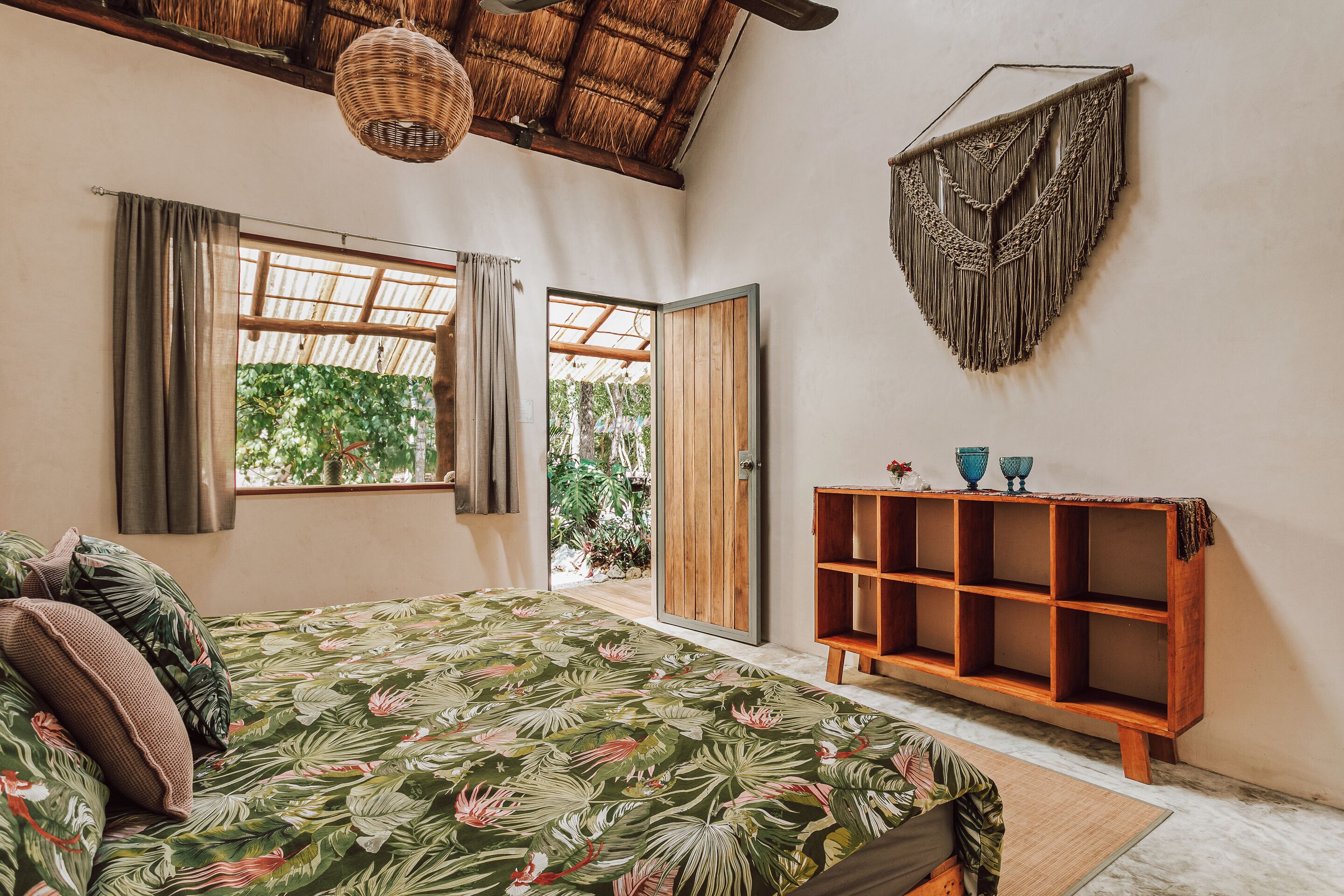 Un dormitorio con una cama, un estante de madera y un tapiz de pared tejido.