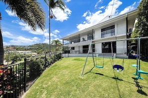 A modern building with a flat roof, large windows, and a balcony. - Broadwater Breeze (Airlie Beach)