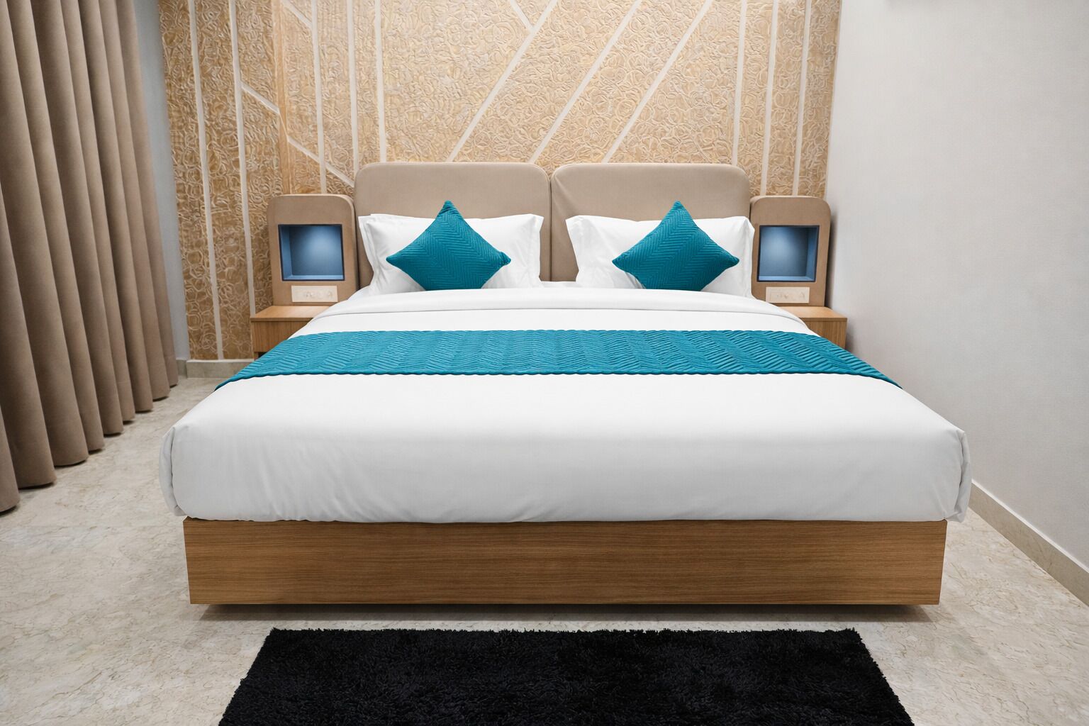 A modern hotel room with a large bed, two bedside tables, a black rug, and a patterned wall.