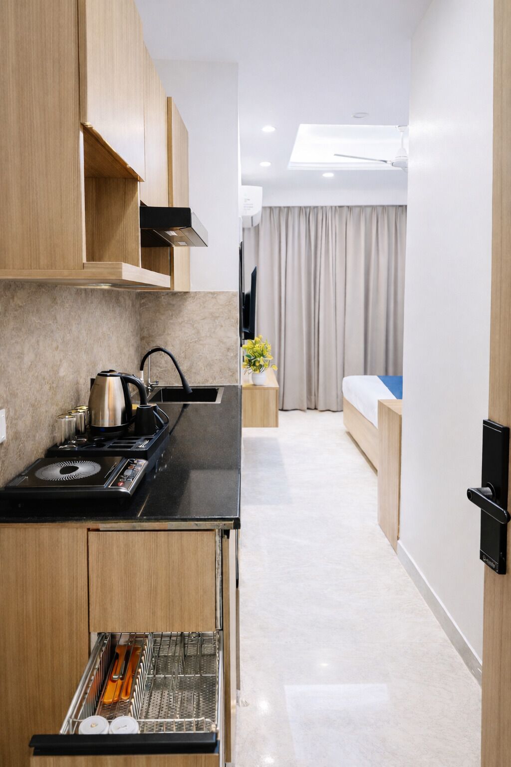 Una cocina moderna con estufa integrada, un escurreplatos y un pequeño comedor con mesa y sillas.