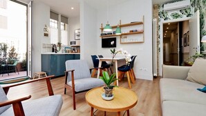 A modern living room with a dining area, wooden furniture, and a potted plant. - Raffinato appartamento con piccolo giardino al Vaticano  (ROMA)