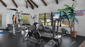 A gym with various exercise equipment, a ceiling fan, and a large window with a view of the outdoors. - Hidden treasure minutes from Pensacola Beach with large pool area! (Gulf Breeze)