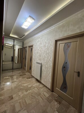 A hallway with patterned walls, a radiator, and a door with a unique design. - Apartment located Mestre center, good connection to Venice&Airport (Venezia)