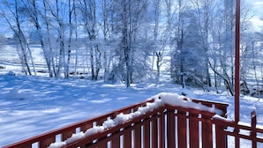 Schneebedeckte Landschaft mit Bäumen und einem Holzbau.