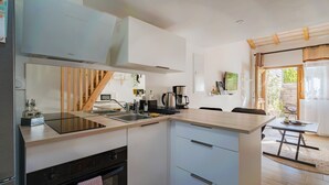 A modern kitchen with a built-in stove, a sink, and a coffee maker. - Studio "Maya" with Private Terrace, Shared Garden, and Wi-Fi (Le Puy-Sainte-Réparade)