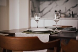 A dining table with two wine glasses, plates, and a mat. - Hostmate - Milano - Schiaparelli - Stazione Centrale (Milano)