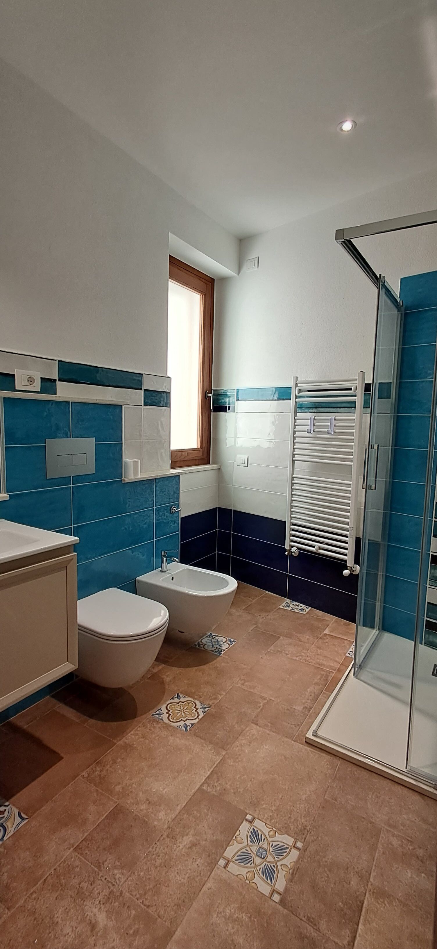 A bathroom with a toilet, bidet, and a glass shower enclosure.