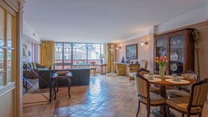 A spacious dining area with a high ceiling, large windows, and a view of the cityscape. - Charme and View in the Heart of Rome (Rome)