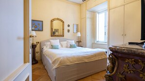 A bedroom with a bed, a dresser, a mirror, and a window. - Charme and View in the Heart of Rome (Rome)
