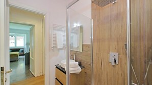 A modern bathroom with a glass shower enclosure, a wooden vanity, and a mirror. - Riboty House al Vaticano (Roma)