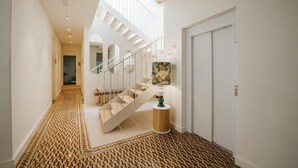 Un interior moderno con una escalera, un suelo estampado y una puerta.
