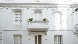 Un edificio de estilo arquitectónico clásico, con una entrada central que tiene una puerta con el número "824" y un balcón con macetas.