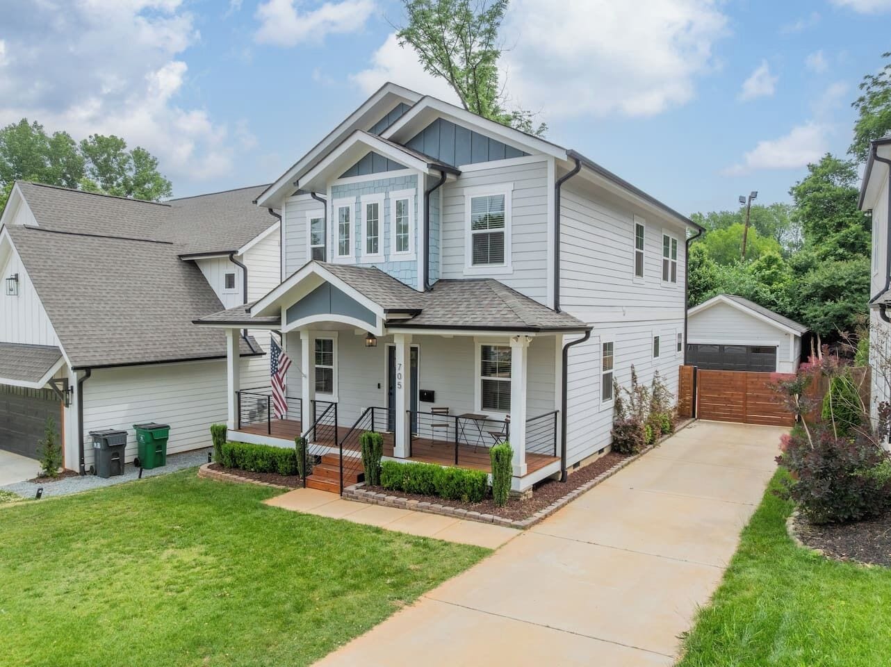 A two-story house with a front porch, a garage, and a well-maintained lawn.