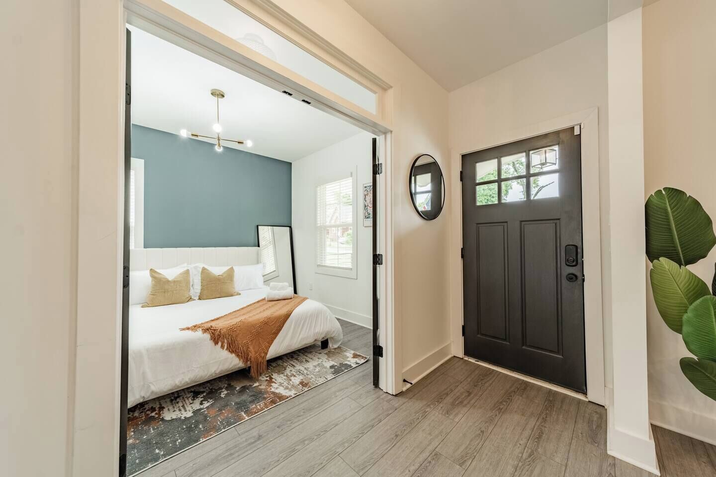 Quarto com cama, espelho e porta.