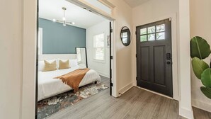 A bedroom with a bed, a mirror, and a door. - Spacious Home-6 Beds | 10 Mins From City Center (Charlotte)