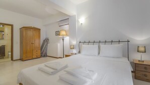 Ein Hotelzimmer mit Bett, Nachttischen, einem Kleiderschrank und einem Spiegel.